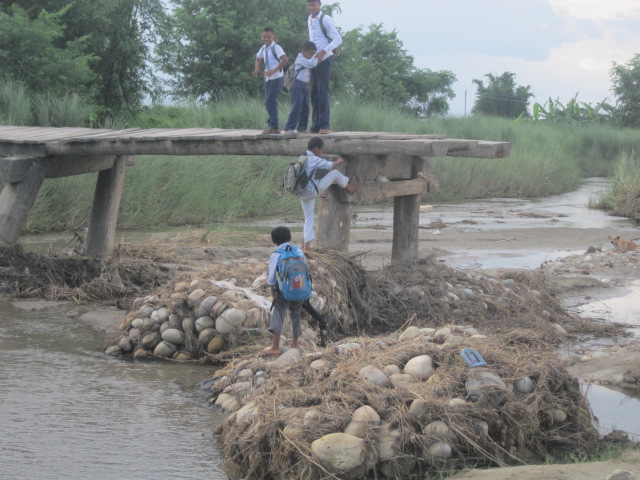 ネパール、鉄砲水で損壊した橋と通学する子どもたち